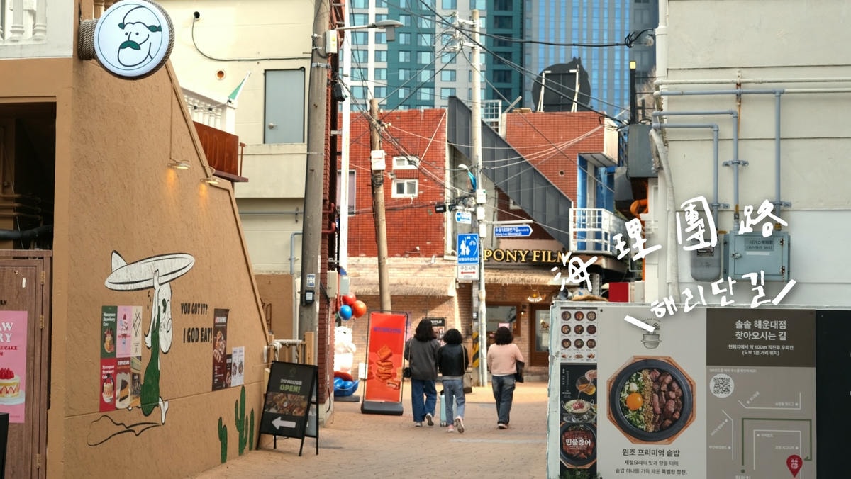 海理團路2025年實拍，色彩繽紛的店家招牌與人潮，展現釜山在地生活風情