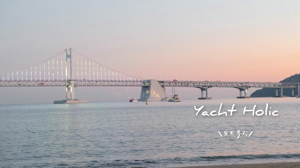 日落下的廣安大橋與Yacht Holic遊艇，2023年拍攝，船家同步施放煙火，展現海上慶典的熱鬧景象。