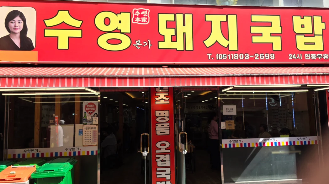 這條街上有多家餐廳，而且一連過去真的都是豬肉湯飯，不認識韓文的朋友們可能會走著走著就錯過了，但其實店家門口非常好辨識，因為它的店招牌上有一名女子的相片，透過這招牌便可以知道就是秀英/水營本家。